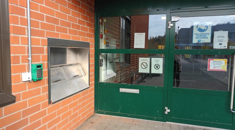 Rantakylän kirjaston sisäänkäynti. Vasemmalla omatoimikirjaston sisäänpääsyyn tarvittava lukulaite.