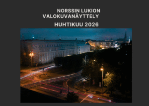 Kuvassa on öinen kaupunki, jossa näkyy suuri a rakennuksia ja valoja. 