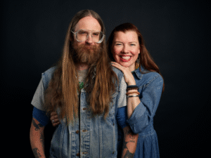 Kuvassa kaksi henkilöä hymyilee. 